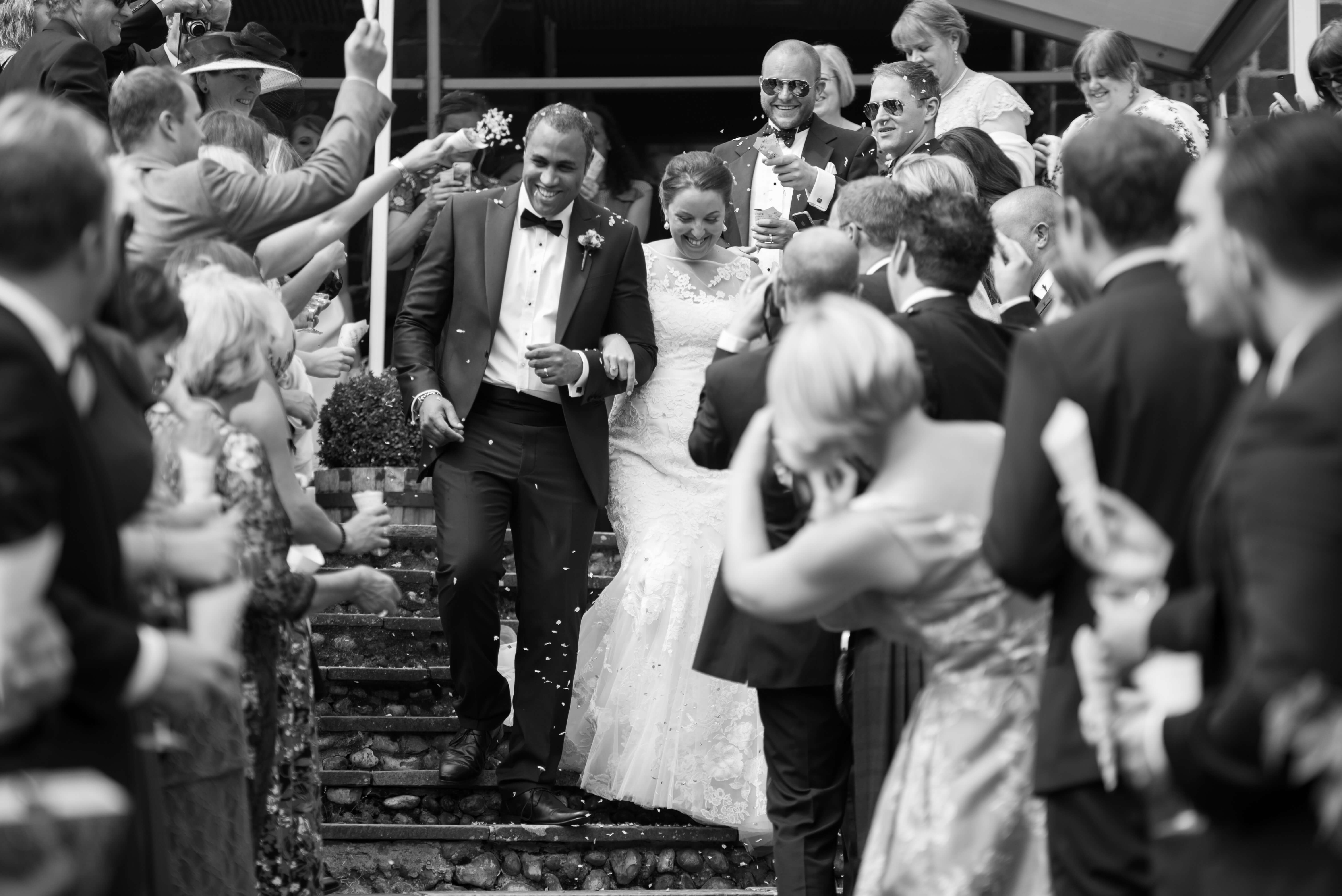 bride and groom with confetti on the steps at voewood in Norfolk